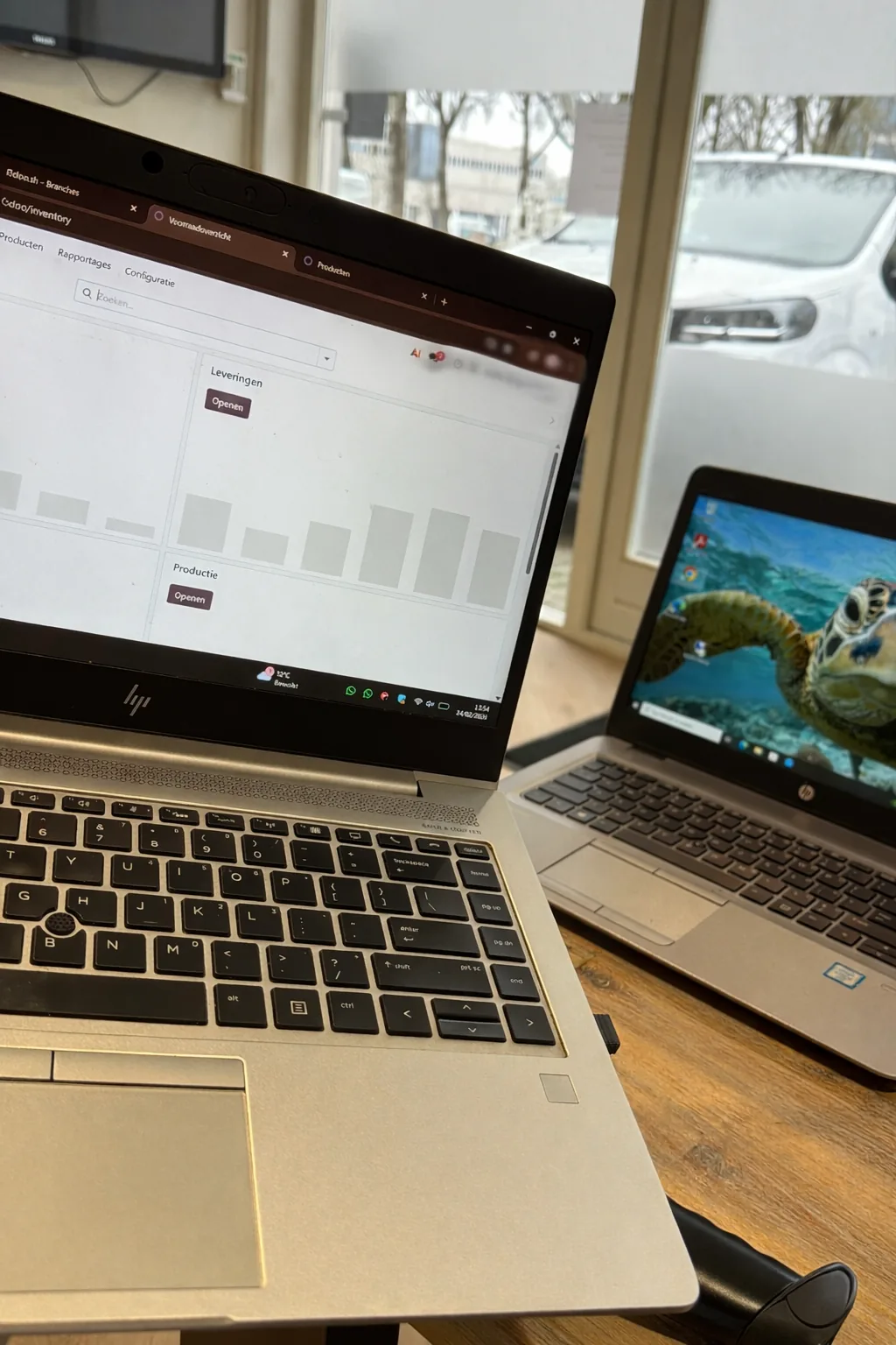 Werkplek met twee laptops op een houten tafel