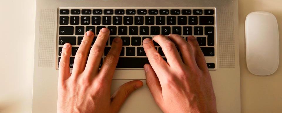 Handen typen op een laptop